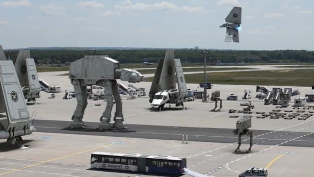 Auf einem Flughafen stehen mehrere AT-ATs und Landungsschiffe aus „Star Wars“.