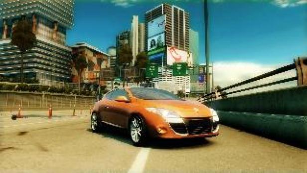 Ein orangefarbener Renault Mégane fährt auf einer Straße in einer Stadt.
