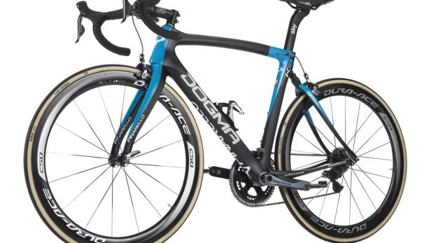 Ein schwarzes und blaues Rennrad der Marke Pinarello Dogma steht vor einem weißen Hintergrund.