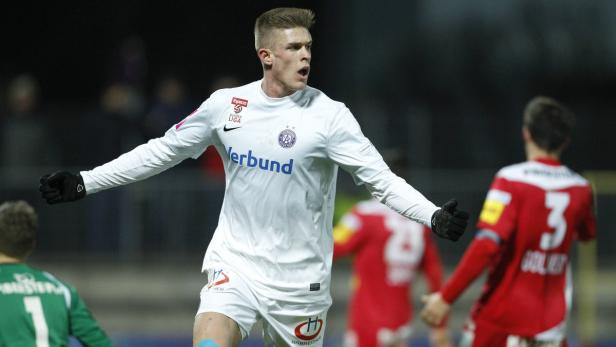 Ein Fußballspieler in weißem Trikot jubelt auf dem Spielfeld.