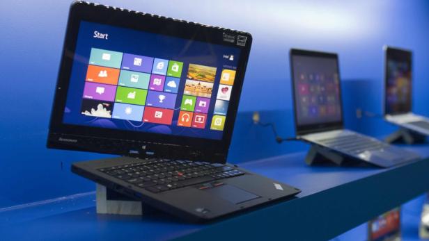 Ein Lenovo Laptop mit Windows-Startbildschirm auf einem blauen Tisch.