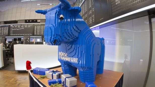 Ein blauer Bulle aus Legosteinen steht vor der Frankfurter Börse, umgeben von Weihnachtsgeschenken.