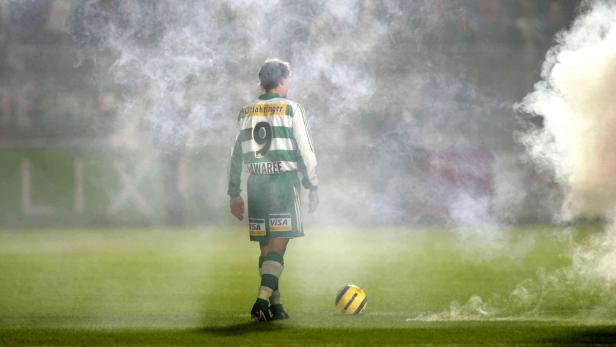 Ein Fußballspieler mit der Nummer 9 steht inmitten von Rauch auf dem Spielfeld.