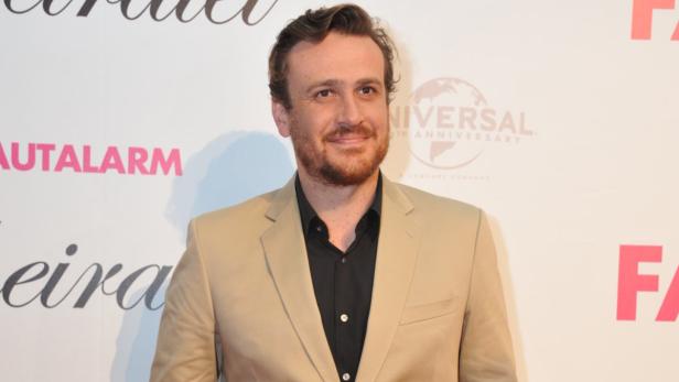 Jason Segel posiert auf einer Veranstaltung in einem beigen Anzug.