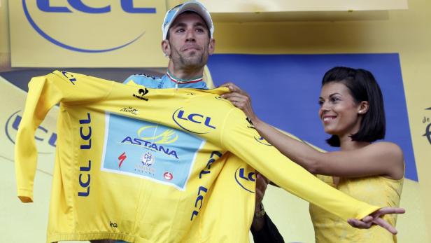 Ein Radrennfahrer erhält ein gelbes Trikot mit der Aufschrift „LCL“.