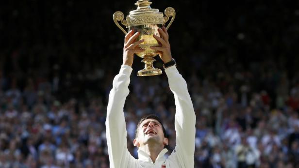Novak Đoković hält die Wimbledon-Trophäe in die Höhe.