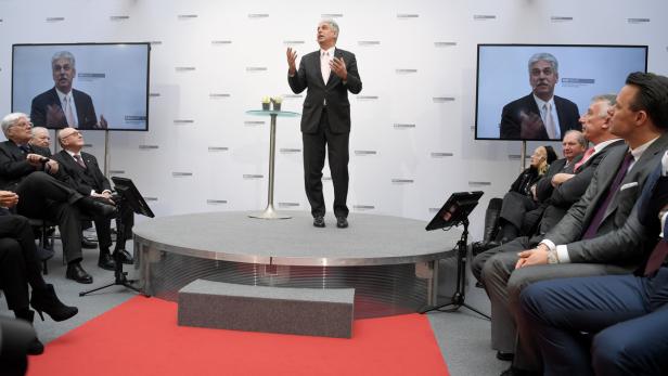 Finanzminister Schelling in Anzug und Krawatte auf einer Bühne