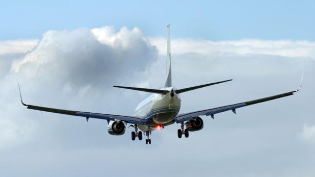 Ein Flugzeug im Landeanflug vor einem bewölkten Himmel.