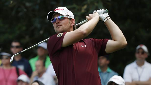 Ein Golfspieler schwingt seinen Schläger vor einer Zuschauermenge.
