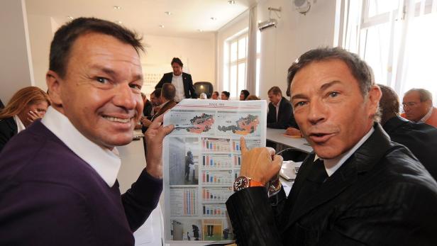 Zwei Männer präsentieren eine Zeitung mit Grafiken zur Wahl 2008 in Österreich.