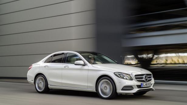 Eine weiße Mercedes-Benz C-Klasse fährt auf einer Straße.