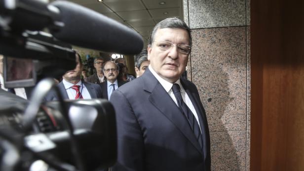 Ein Mann im Anzug steht vor einer Gruppe von Menschen und einer Kamera.