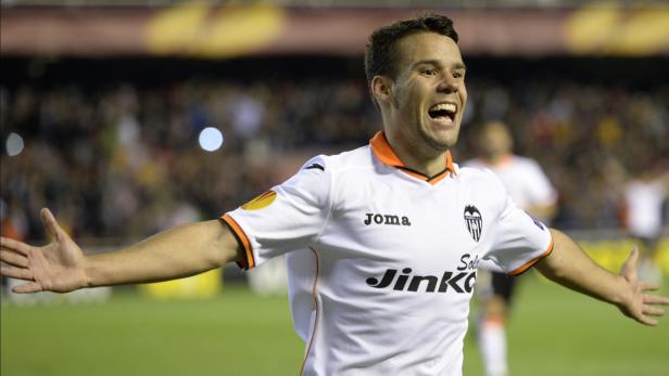 Ein jubelnder Fußballspieler im weißen Trikot des FC Valencia mit ausgestreckten Armen.