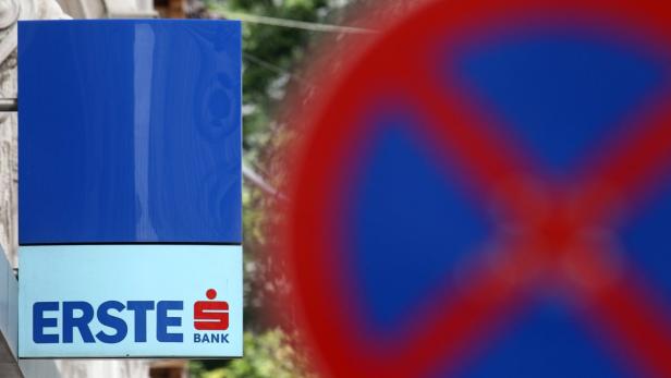 The logo of Austrian Erste Group Bank is pictured on the wall of a branch office behind a traffic sign in Vienna June 6, 2012. Moody&#039;s Investors Service cut the long-term rating for Erste Group Bank by two notches to A3 from A1 and assigned a negative outlook. Austrian banks&#039; operations in emerging Europe are primarily in stable markets with good prospects, central bank Governor Ewald Nowotny said on Wednesday, playing down news that Moody&#039;s had cut ratings for three big lenders. REUTERS/Heinz-Peter Bader (AUSTRIA - Tags: BUSINESS)