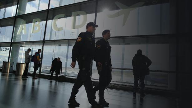 Zwei Polizisten patrouillieren in einem Flughafenterminal.