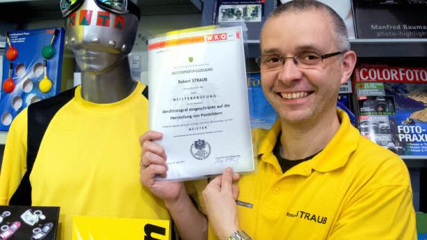 Robert Straub präsentiert sein Meisterprüfungszeugnis als Berufsfotograf für Passbilder.