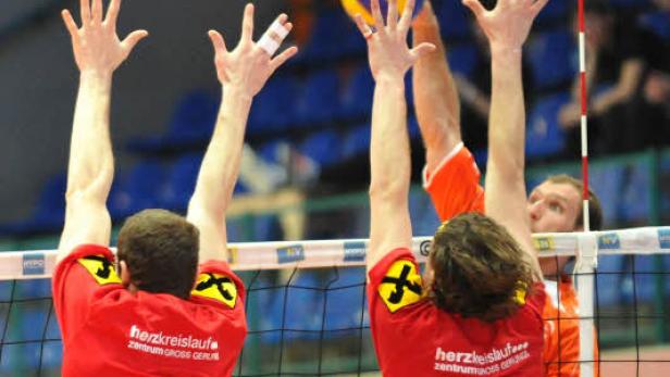 Volleyballspieler versuchen, den Ball über das Netz zu schlagen.