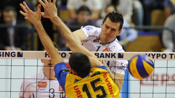 Zwei Volleyballspieler kämpfen am Netz um den Ball.