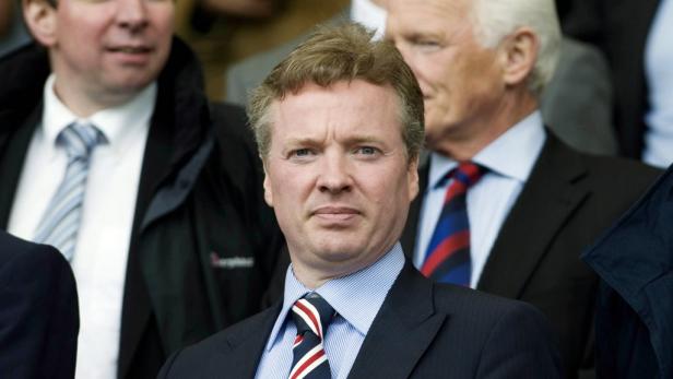 Ein Mann mit Anzug und Krawatte blickt in die Kamera.