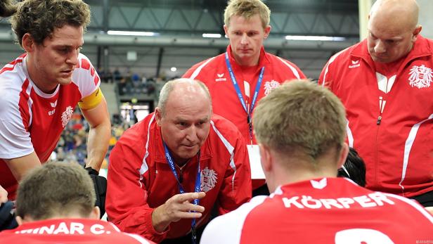 Ein Trainer bespricht sich mit seiner Handballmannschaft in einer Auszeit.