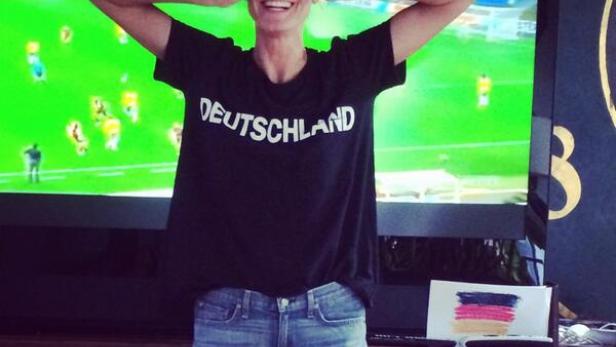 Eine Frau mit einem „Deutschland“-T-Shirt hält sich beim Fußballspiel die Augen zu.