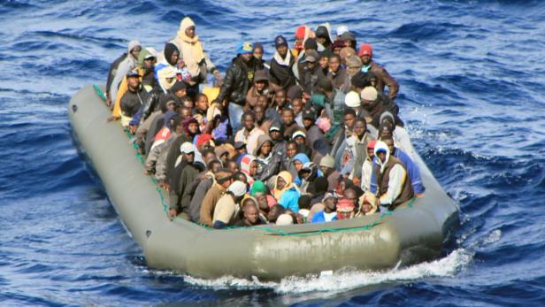 Ein überfülltes Schlauchboot treibt auf dem offenen Meer.