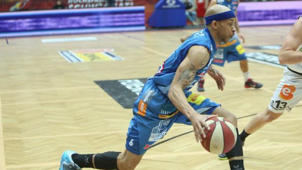 Ein Basketballspieler dribbelt den Ball auf dem Spielfeld.