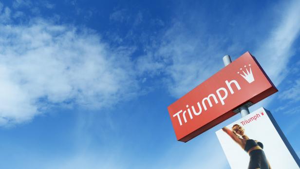 Ein Schild mit der Aufschrift „Triumph“ vor blauem Himmel.