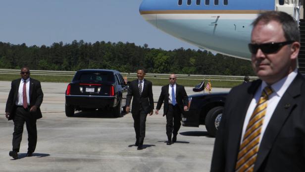 Barack Obama geht mit Begleitern vor der Air Force One entlang.