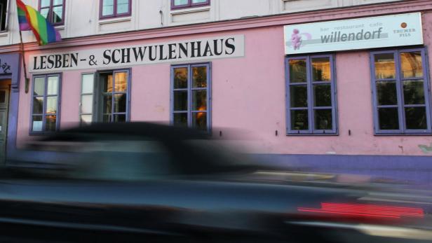 Das Lesben- und Schwulenhaus Willendorf mit Regenbogenflagge und vorbeifahrendem Auto.