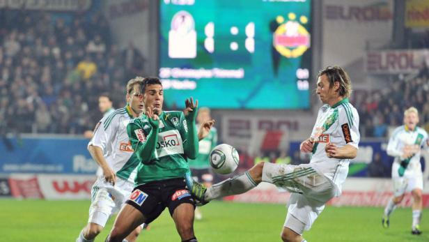 Zwei Fußballspieler kämpfen um den Ball während eines Spiels.