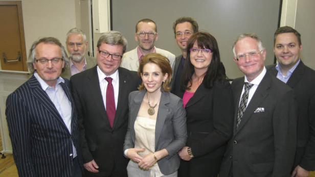 Eine Gruppe von neun Personen posiert für ein Gruppenfoto.