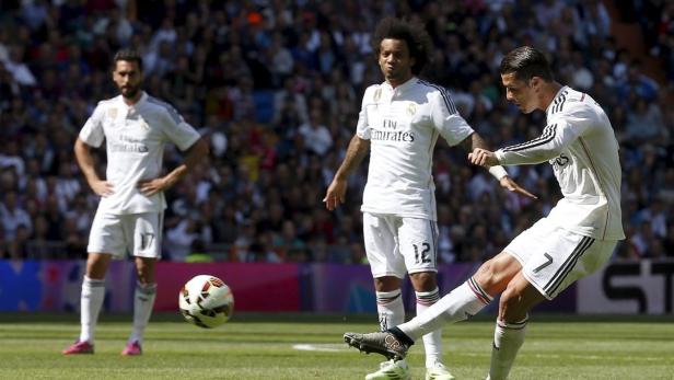 Cristiano Ronaldo schießt einen Fußball, während seine Teamkollegen zusehen.