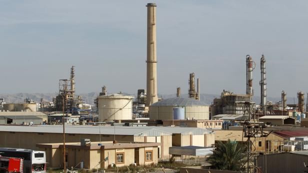 Eine große Industrieanlage mit mehreren Schornsteinen und Gebäuden im Vordergrund.