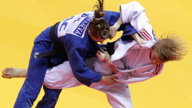 Zwei Judoka kämpfen auf einer gelben Matte.
