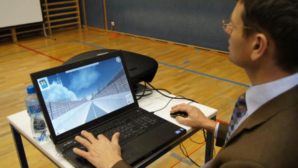 Ein Mann mit Brille bedient einen Laptop mit einer Straßenansicht.