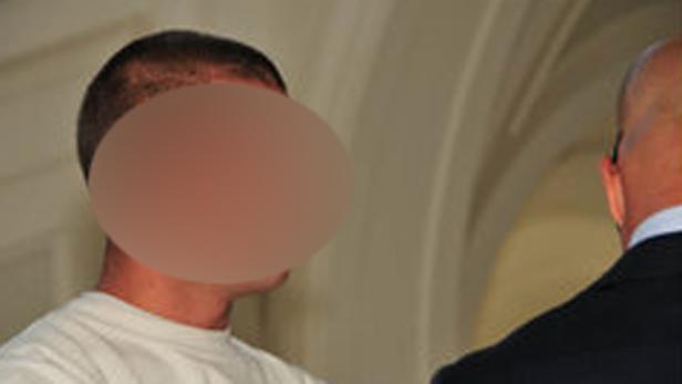 Ein Mann mit verpixelten Gesicht steht einer anderen Person gegenüber.