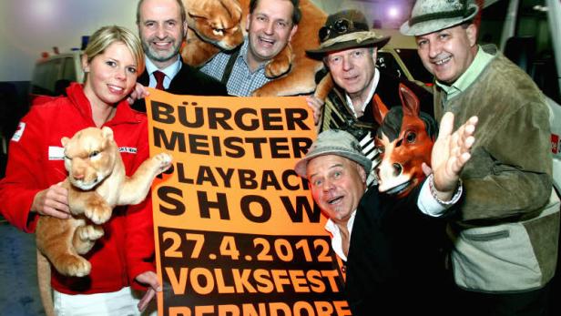 Eine Gruppe von Personen hält ein Plakat für die „Bürgermeister Playback Show“ am 27.4.2012 in Berndorf.