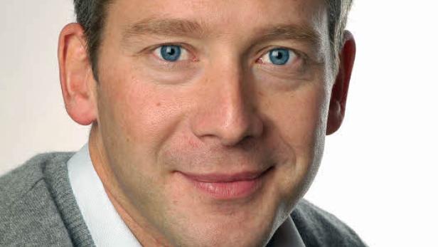 Porträt eines Mannes mit hellbraunen Haaren und blauen Augen.