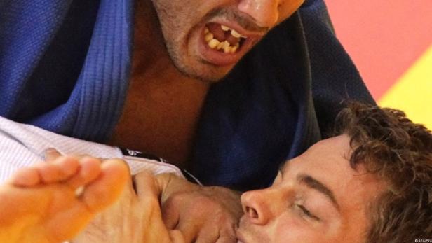 Zwei Judoka kämpfen auf der Matte, einer schreit mit offenem Mund.