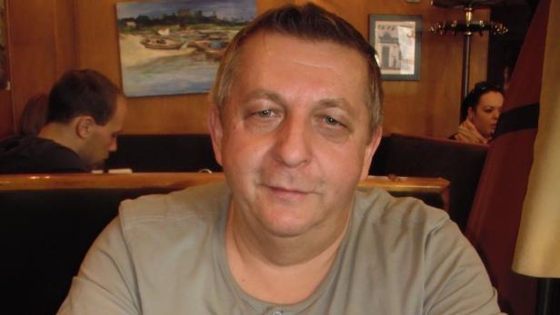 Ein Mann sitzt in einem Restaurant oder Café.