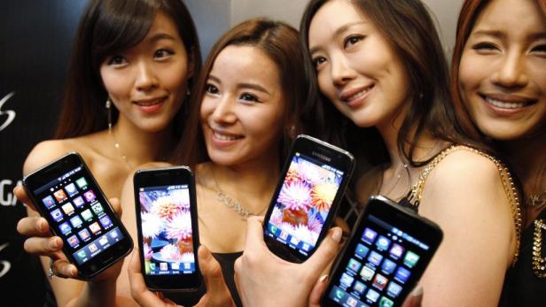Vier Frauen präsentieren lächelnd Samsung Galaxy Smartphones.