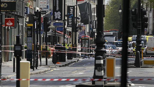 Eine abgesperrte Straße in London mit Polizei- und Rettungsfahrzeugen.