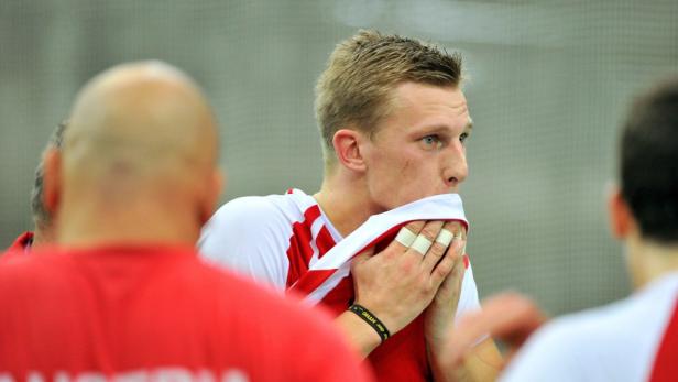 Ein erschöpfter Sportler mit bandagierten Fingern hält ein Trikot vor sein Gesicht.