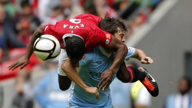 Ein Fußballspieler wird von einem anderen während eines Spiels Huckepack genommen.