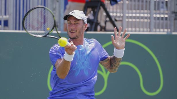 Ein Tennisspieler schlägt einen Ball mit seinem Schläger.