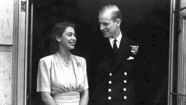 Ein Schwarzweißfoto von Königin Elisabeth II. und Prinz Philip, die sich anlächeln.