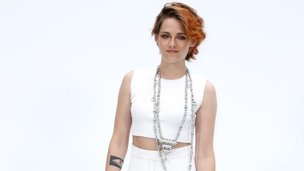 Kristen Stewart trägt ein weißes Outfit und eine lange Halskette.