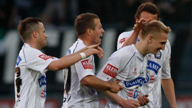 Fußballspieler feiern gemeinsam auf dem Spielfeld.
