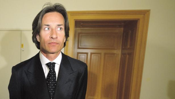 Ein Mann im Anzug blickt zur Seite.